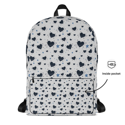 White backpack with all-over navy heart and star pattern, front pocket and visible inside pocket label 