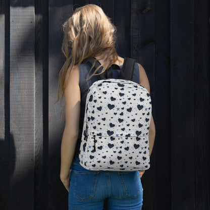 Woman wearing white backpack with all-over navy heart and star pattern, front pocket and visible inside pocket 