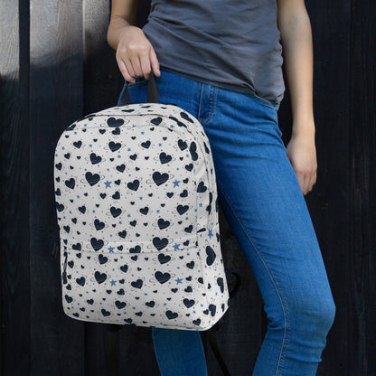 Woman wearing white backpack with all-over navy heart and star pattern, front pocket and visible inside pocket 