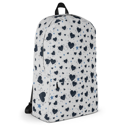 White backpack with all-over navy heart and star pattern, front pocket and visible inside pocket label 