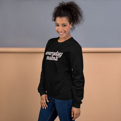 Woman wearing a black sweatshirt with 'everyday mama' text against a neutral background
