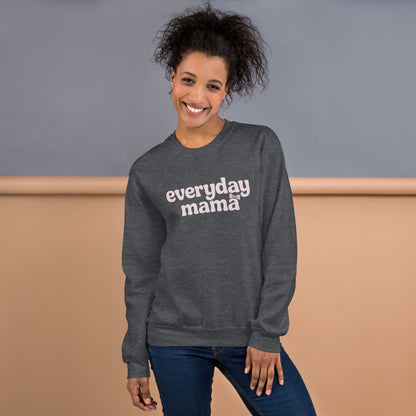 Woman wearing a gray sweatshirt with 'everyday mama' text against a neutral background