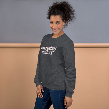 Woman wearing a gray sweatshirt with 'everyday mama' text against a neutral background