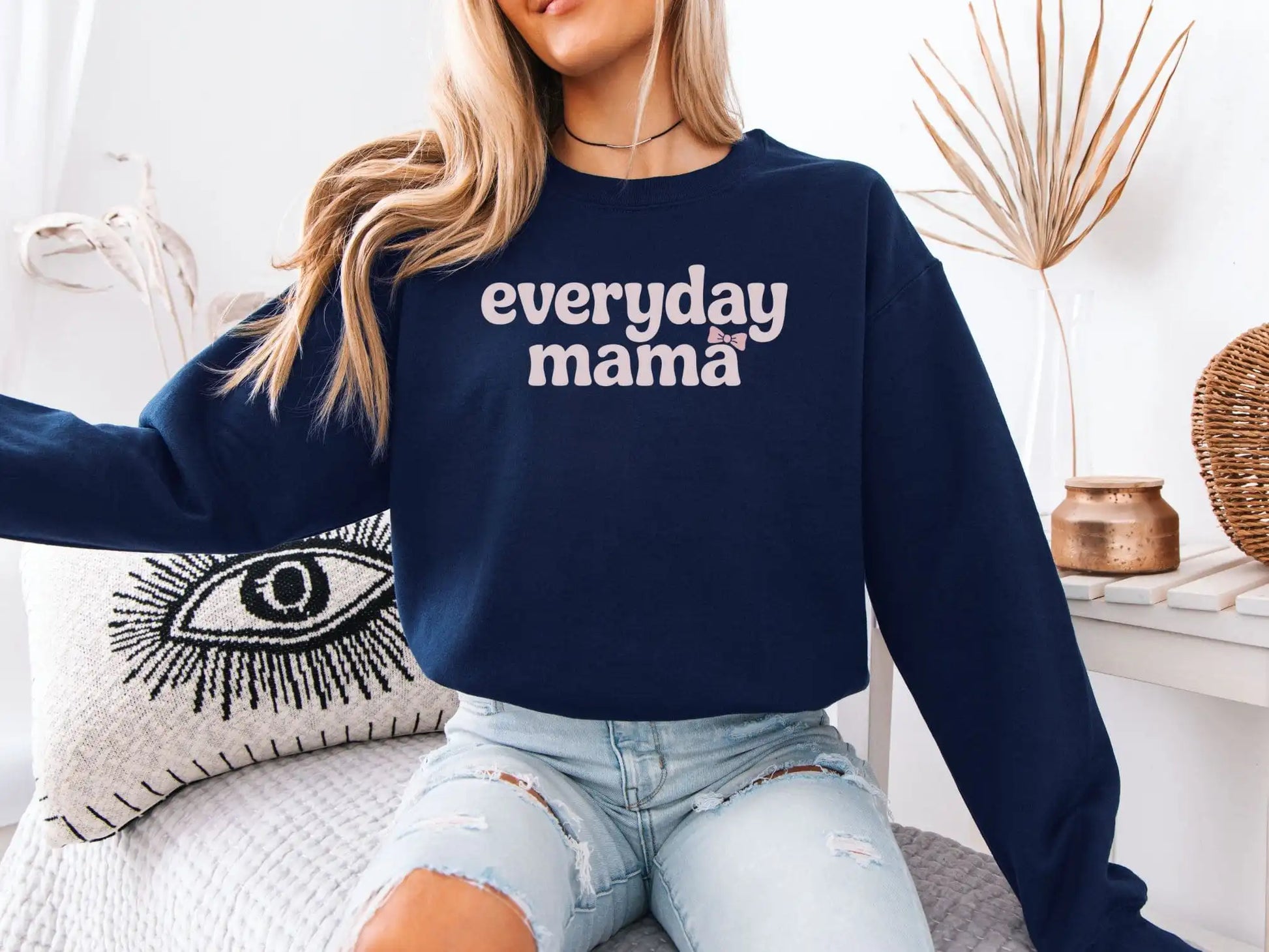 Model wearing navy Everyday Mama sweatshirt with pink bow graphic