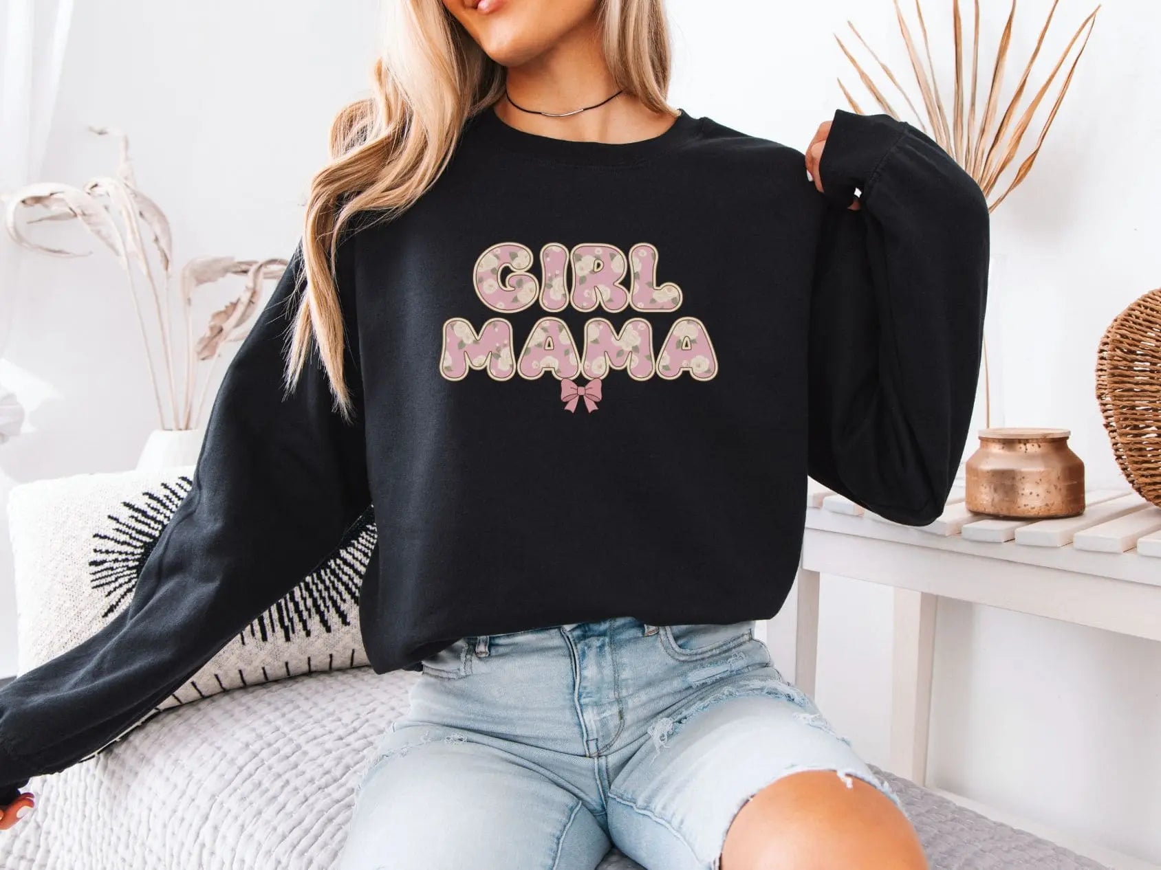 Person wearing a black sweatshirt with 'GIRL MAMA' text in a home setting