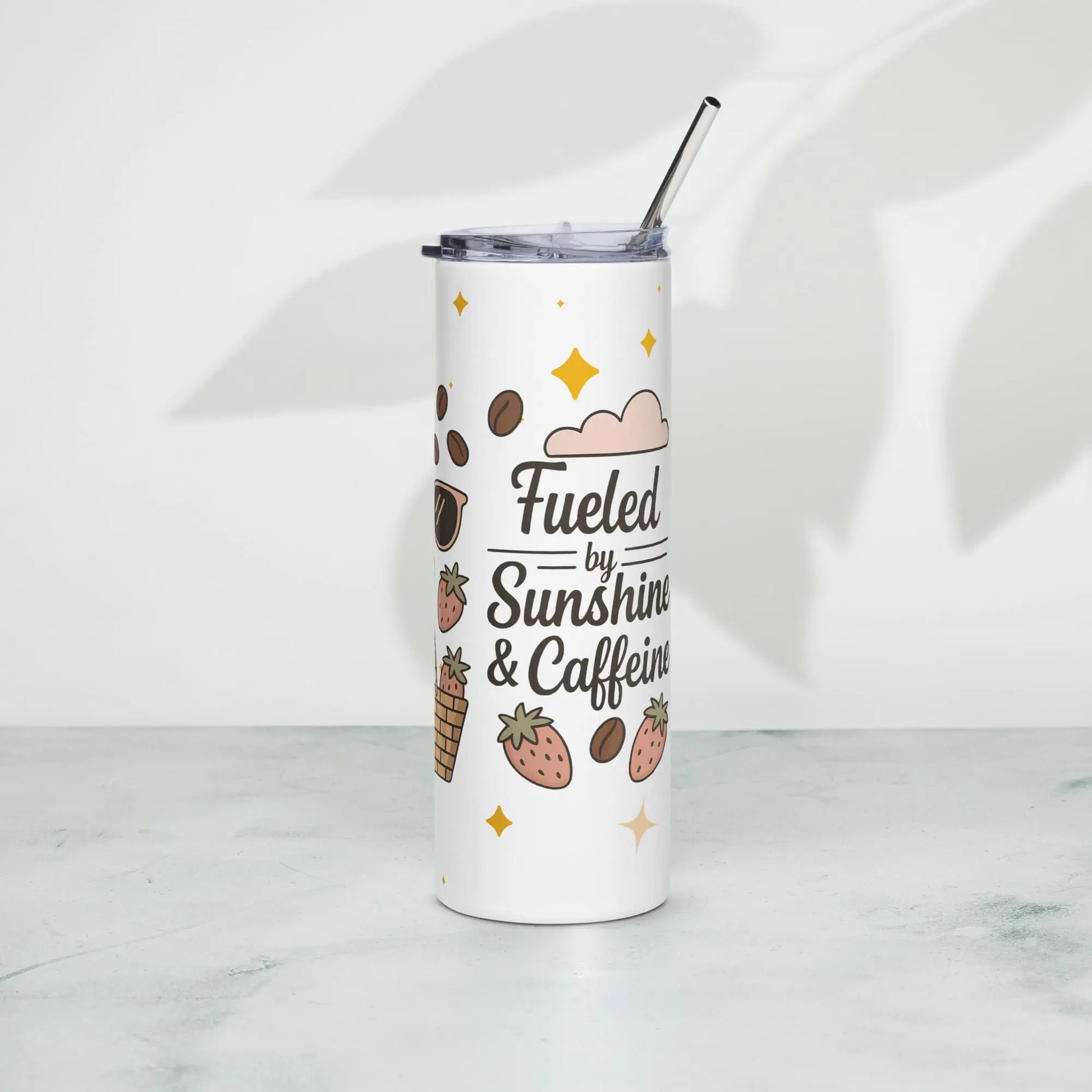 Left side view of white stainless steel tumbler with pastel illustrations and ‘Fueled by Sunshine & Caffeine’ quote. Displayed on marble surface with soft shadows.