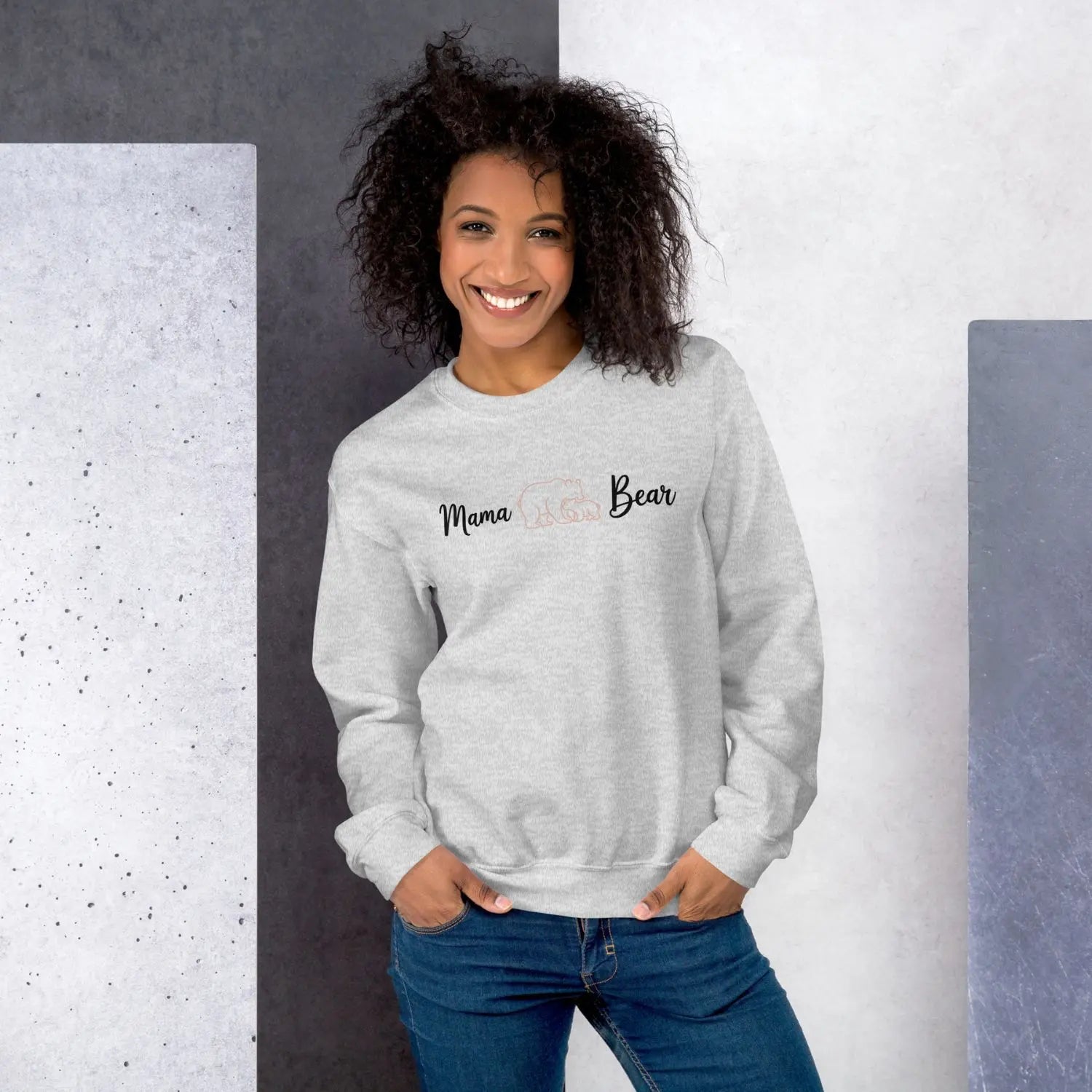 Woman wearing a gray sweatshirt with 'Mama Bear' text against a gray and white background