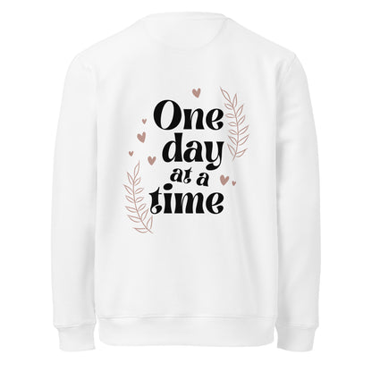  White unisex sweatshirt with 'One day at a time' quote and floral heart decorations on the back.