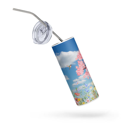 Spring-themed stainless steel tumbler floating at an angle with lid and straw detached, featuring cherry blossoms, butterflies, and wildflowers under a blue sky with clouds on a white background.