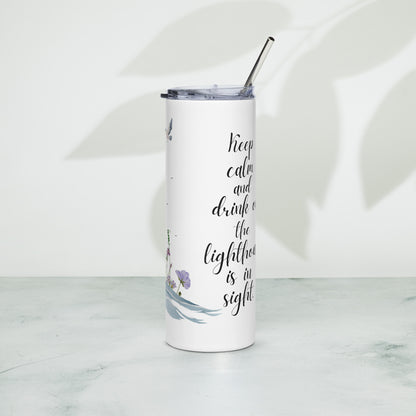 Stainless steel tumbler with a lighthouse-themed design and the phrase “Keep calm and drink on, the lighthouse is in sight,” standing on a textured surface with soft leaf shadows in the background.