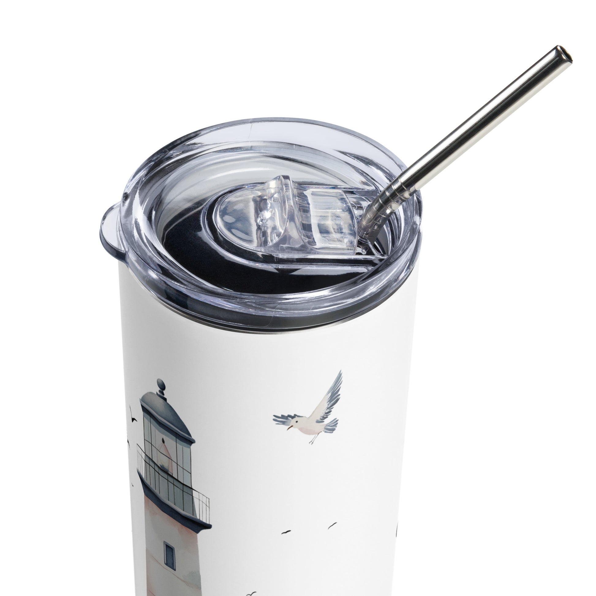 Close-up of a white stainless steel tumbler with a lighthouse and seagull design, silver straw, and transparent lid.