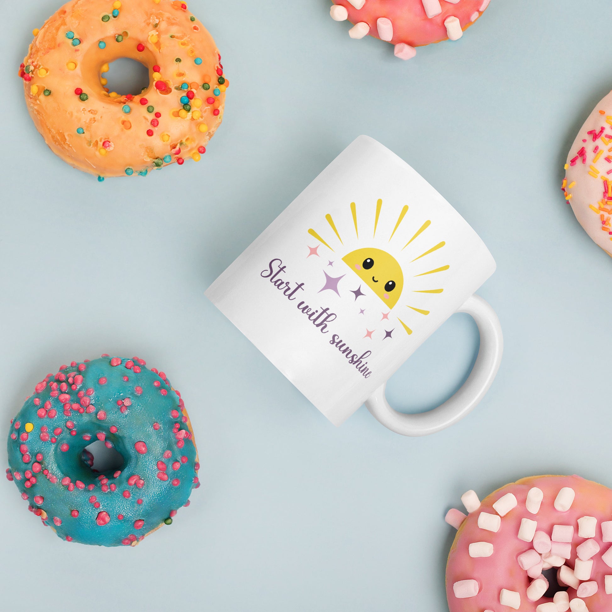 White ceramic mug with cute sun and sparkles surrounded by colorful donuts — fun pastel coffee cup perfect for sweet summer mornings.