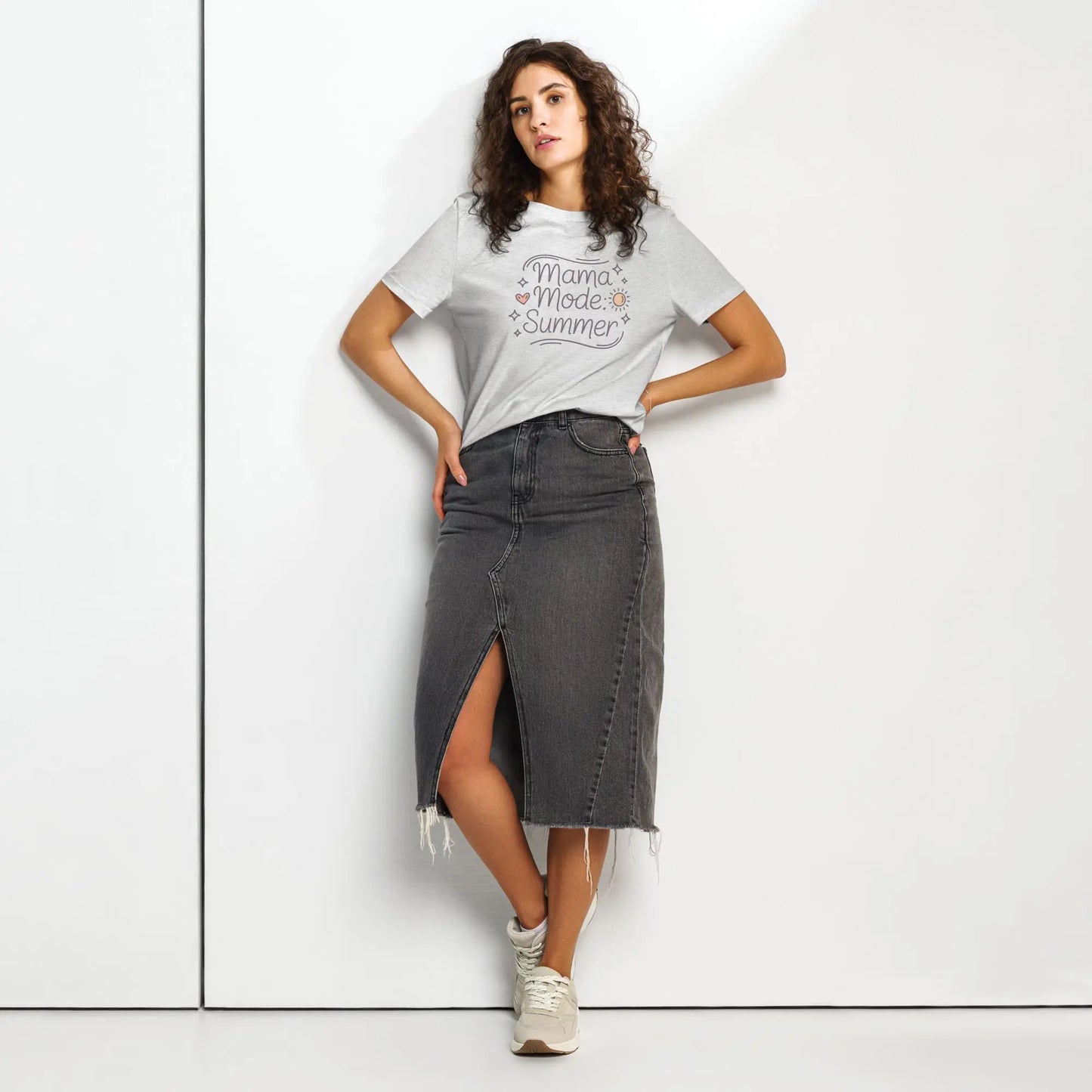 Model wearing grey 'Mama Mode: Summer' t-shirt paired with a dark denim skirt, standing against a white background