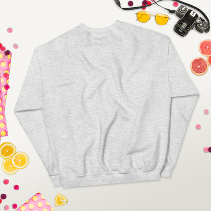 Back view of a ash gray unisex crew neck sweatshirt laid flat on a colorful background with fruits, sunglasses, and a camera.
