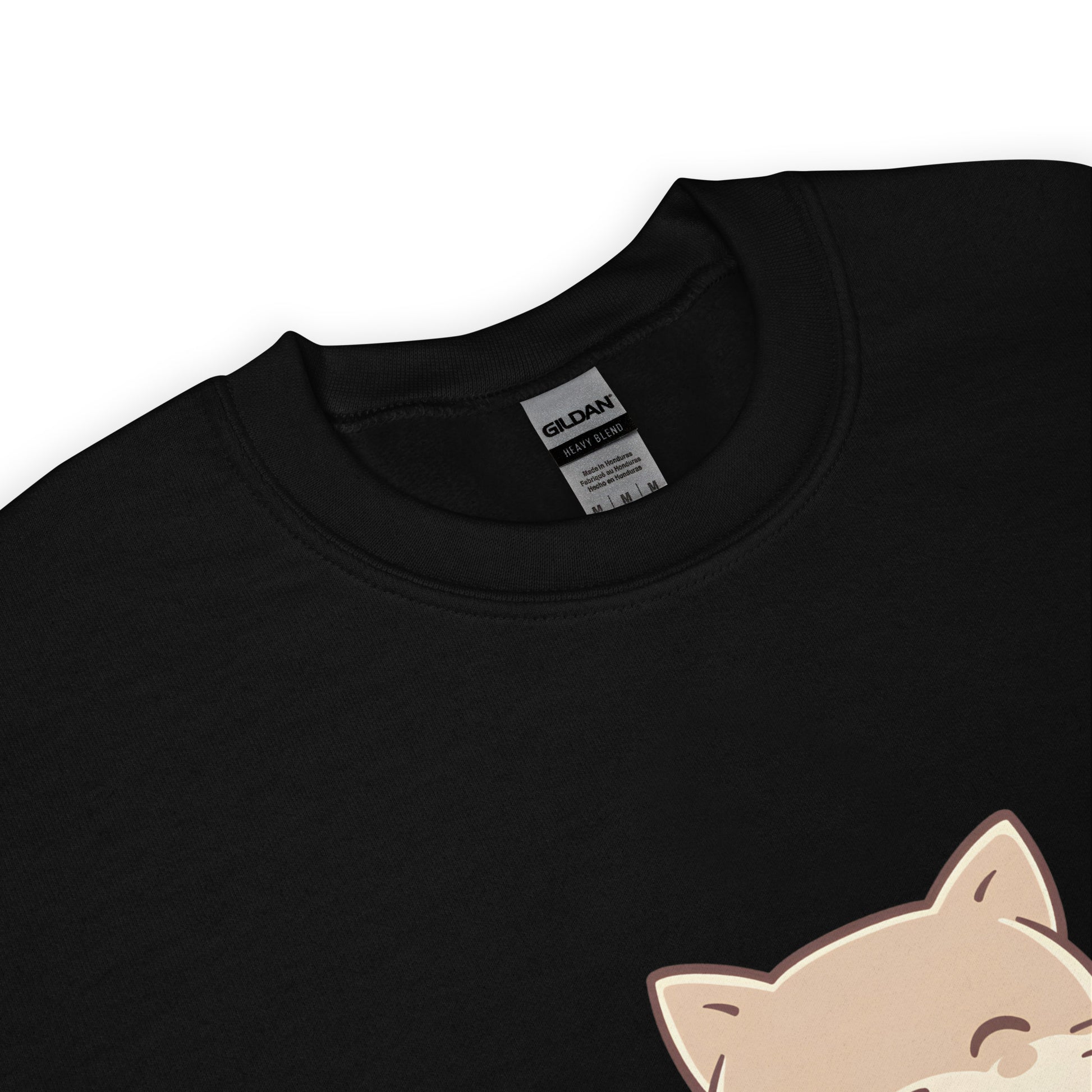 Close-up of the collar and tag of a black Gildan sweatshirt featuring a partial view of a cute cat illustration from the “Stay Kind” design.
