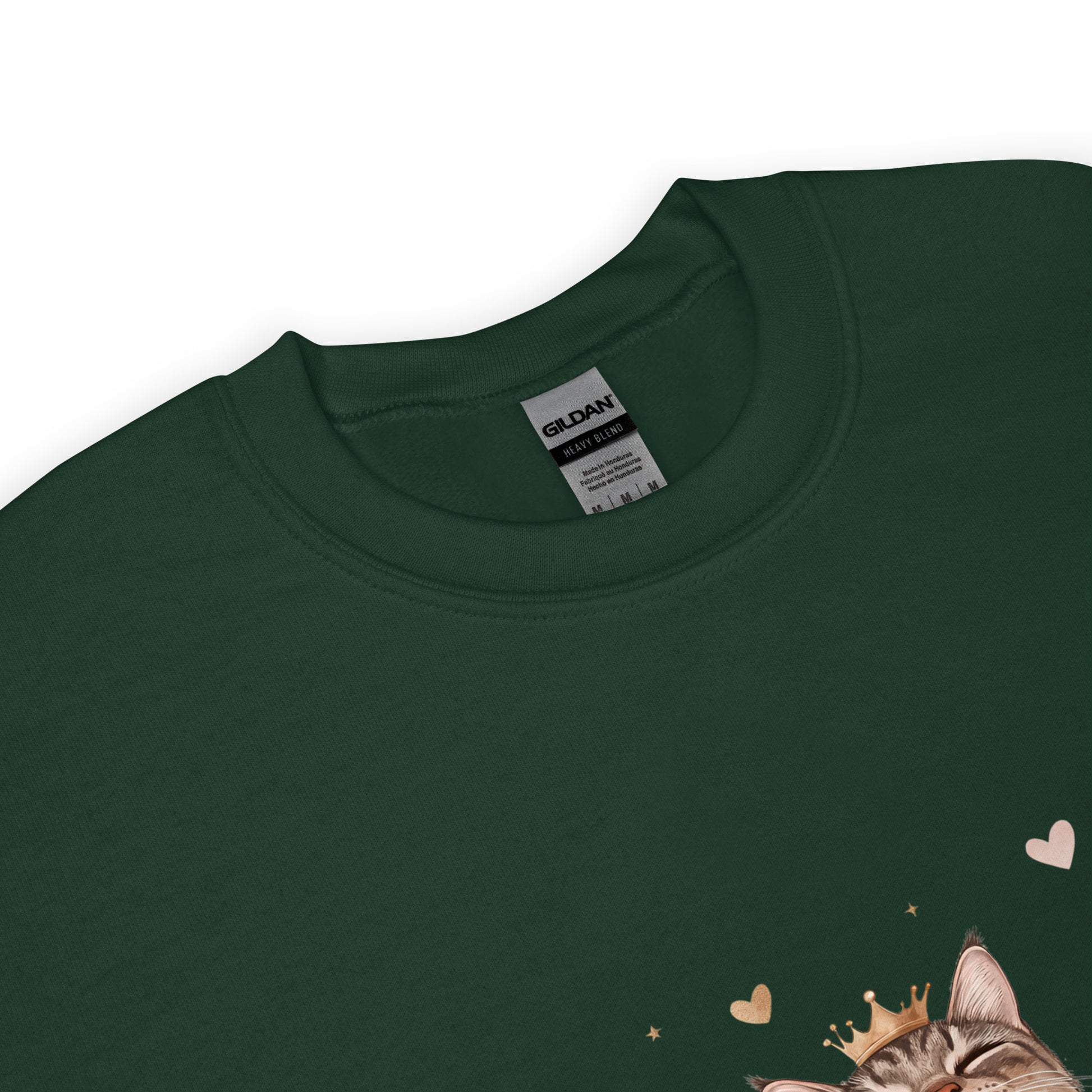 Close-up of a forest green sweatshirt collar with Gildan label visible and part of a cat graphic wearing a crown with tiny hearts.