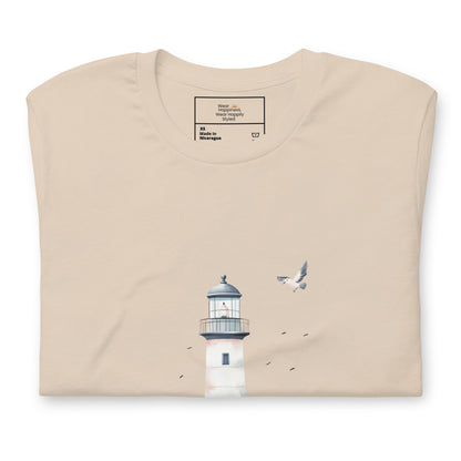 Flat-lay of a folded soft cream-colored t-shirt featuring a minimal lighthouse and seagull design, styled for a calming, nature-inspired mom aesthetic.