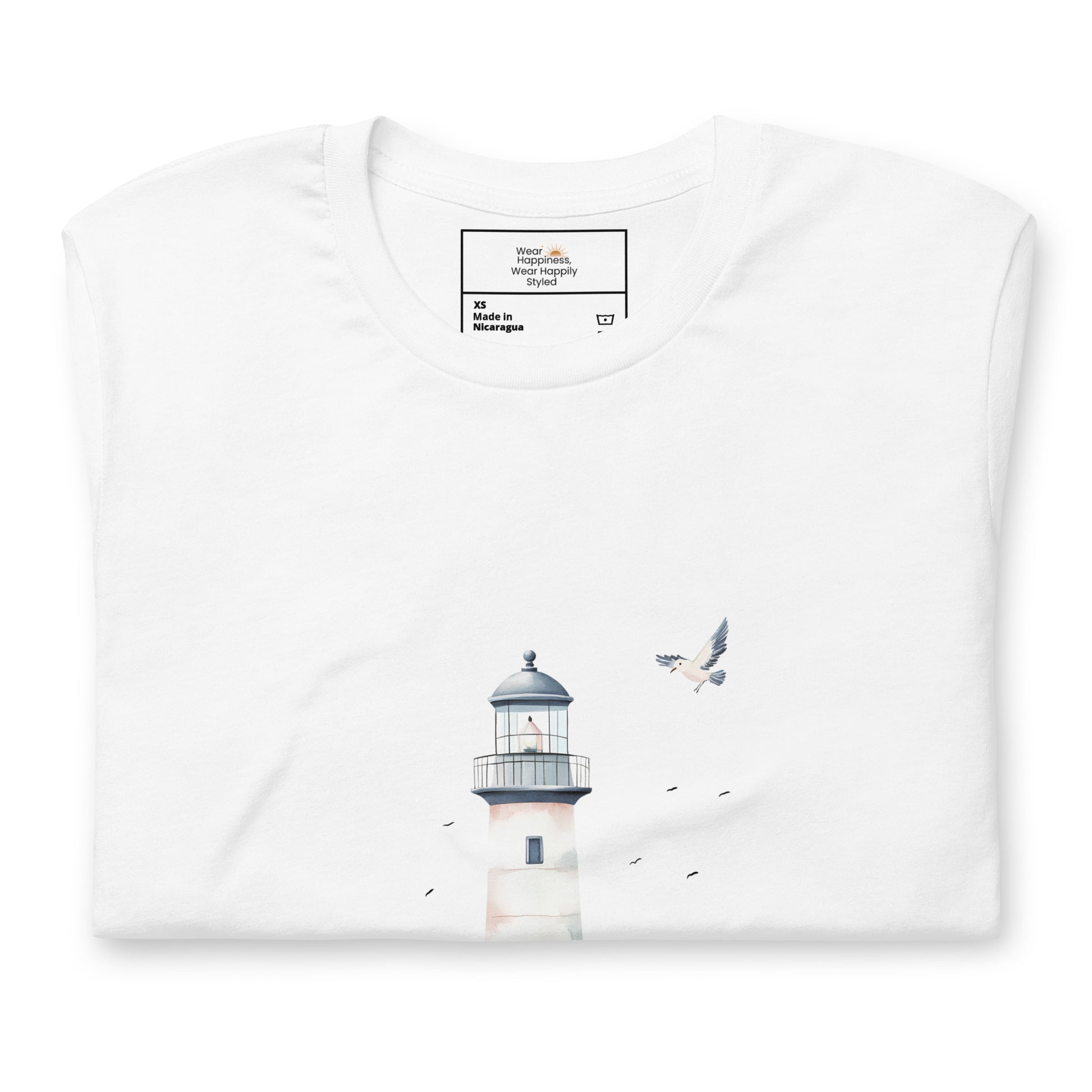 Flat-lay of a folded white t-shirt featuring a minimal lighthouse and seagull design, styled for a calming, nature-inspired mom aesthetic.