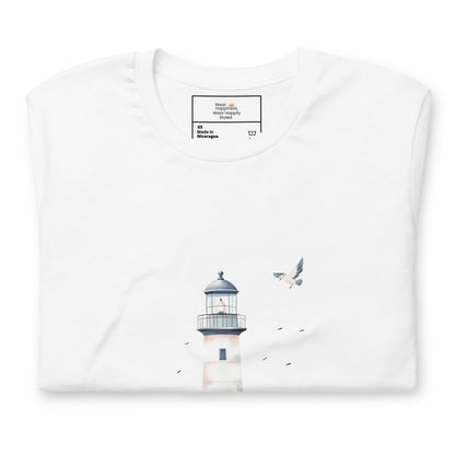 Flat-lay of a folded white t-shirt featuring a minimal lighthouse and seagull design, styled for a calming, nature-inspired mom aesthetic.